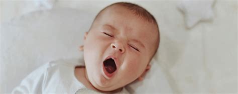 Ilustračná fotografia matky, ktorá sa snaží uspať bábätko na fitlopte s výrazom únavy.