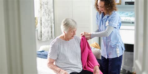 Fotografia znázorňujúca opatrovateľa, ktorý pomáha osobe s demenciou pri osobnej hygiene.