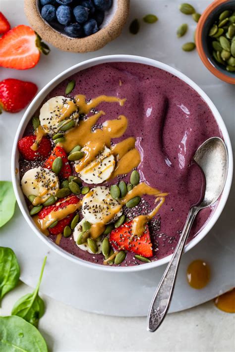 Pestrá a farebná smoothie bowl ozdobená ovocím, orechmi a semienkami.