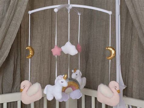 Fotografia farebných hračiek pre bábätko: kolotoč nad postieľku, plyšový medvedík, textilná knižka.