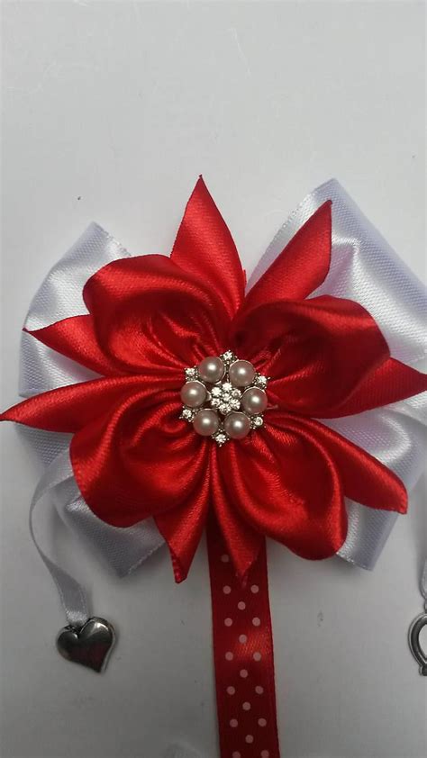 Detail červenej mašličky s menom dieťatka a príveskami