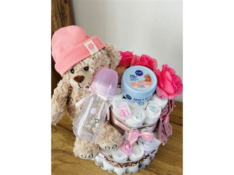 Detail plienkovej torty s menom dieťatka a plyšovým medvedíkom.