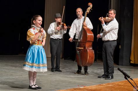 Ilustrácia rodiča, ktorý drží dieťa a spieva mu uspávanku