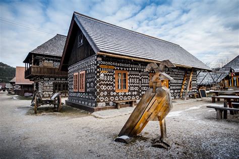 Fotografia tradičných čičmianskych domov zdobených bielou ornamentikou.