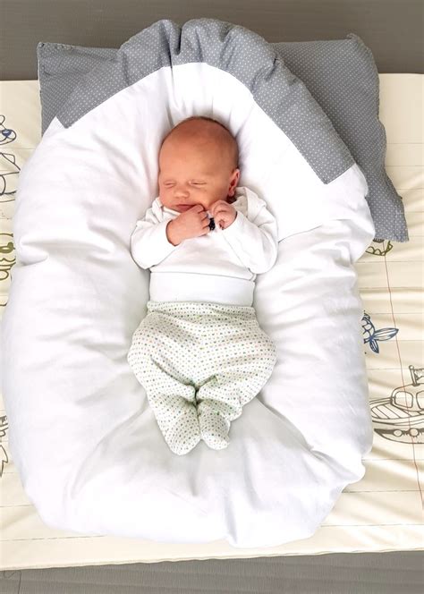 Ilustrácia bábätka spinkajúceho v páperovej zavinovačke