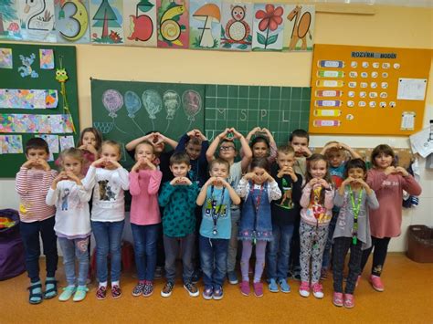 Ilustrácia detí v triede, kde jedno dieťa (vykonávateľ) sleduje inštrukcie na tabuli a druhé deti (kontrolóri) ho pozorujú.