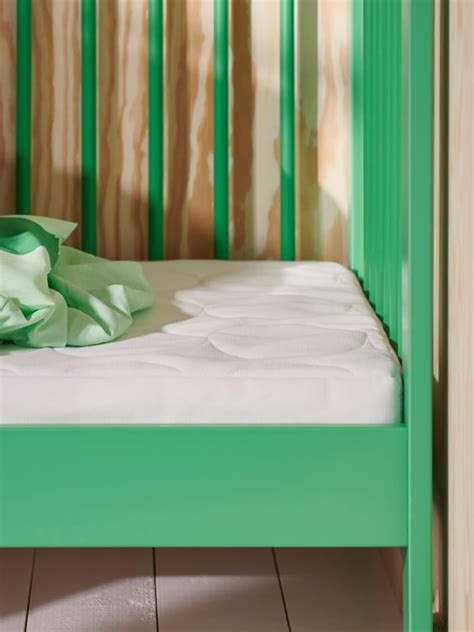 Detail detskej postieľky IKEA s obhryzenou farbou na bočnici