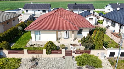 Fotografia rodinného domu s upravenou záhradou a ihriskom