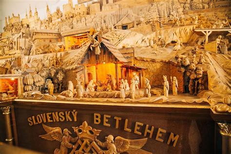 Slovenský betlehem s vyrezávanými figúrkami, zobrazujúci scénu narodenia Ježiša.