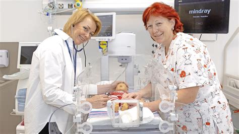 Fotografia predčasne narodeného bábätka v inkubátore s prítomnosťou matky.