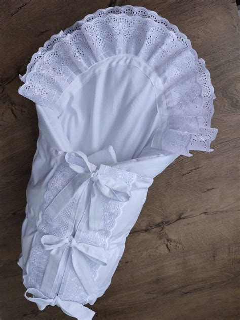 Kojenecká perinka na krst z jemného bavlneného saténu s detailmi z perličkovej čipky a volánikom.