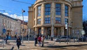 Fotografia budovy školy v Lotyšsku, ktorá kombinuje modernú a historickú architektúru.