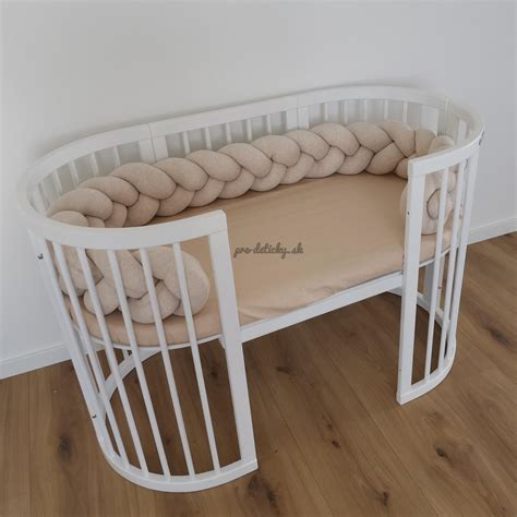 Ilustračná fotografia elegantnej drevenej detskej postieľky.