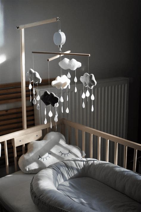 Jednoduchý DIY kolotoč z čierno-bielych stužiek zavesený nad prebaľovacím pultom.