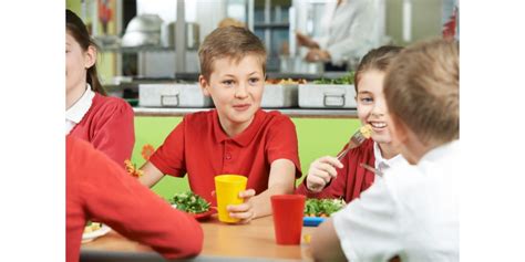 Deti pri spoločnom stole, ktoré jedia rôzne druhy jedla.